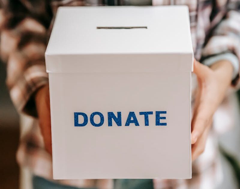 Hands of an anonymous person holding a donation box
